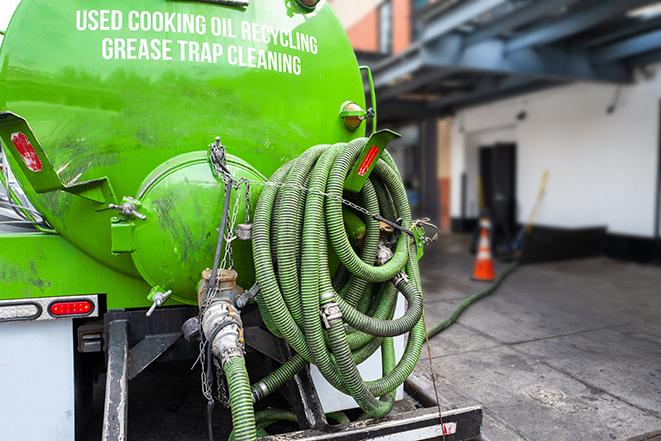 a grease trap being pumped by a sanitation technician in San Carlos, CA